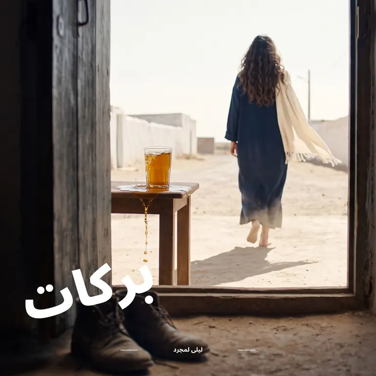 امرأة خارجة من باب دار نحو زنقة مشمسة، وكاس أتاي فايض على طبلة حدا الباب
